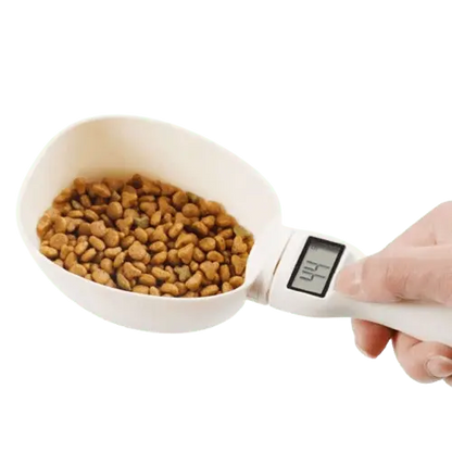 Electronic measuring spoon for pet food, shown with dog kibble