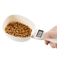 Electronic measuring spoon for pet food, shown with dog kibble